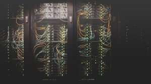 Network switch with blue fiber optic cables and active port indicators in a data center